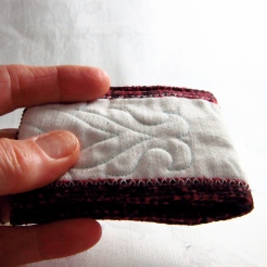 Hand made machine quilted red and white oyster card wallet by artist Maggie Winnall